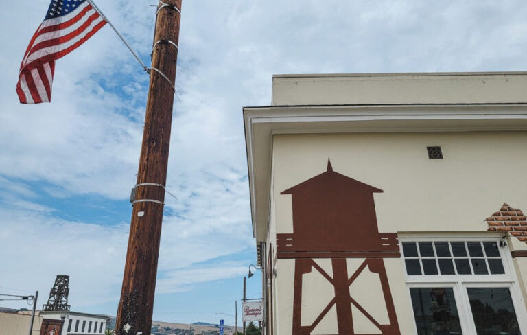 American flag outside building with barn mural.