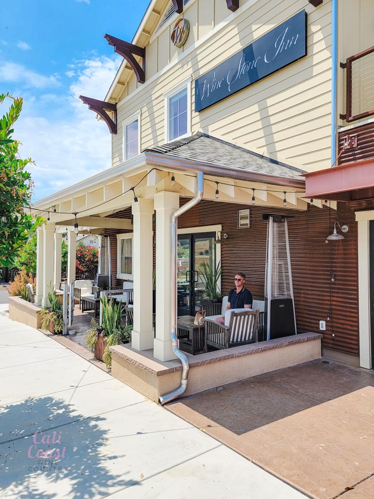 Guest relaxing at Wine Stone Inn facade.