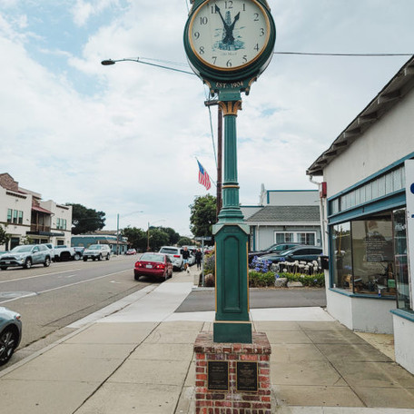 Vintage street clock on sidewalk with cars