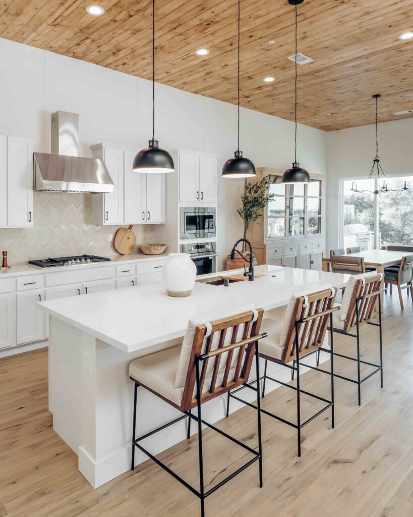 Modern kitchen interior with island and pendant lights.