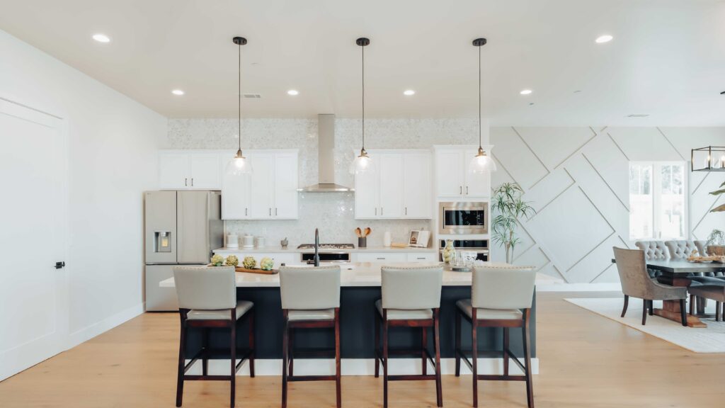 Modern kitchen interior with island and pendant lights.