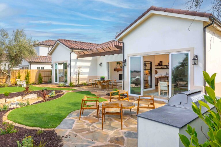 Modern backyard patio with landscaping and outdoor furniture.