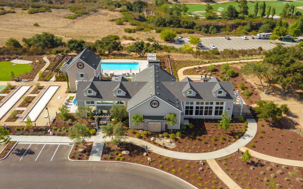 Aerial view of suburban clubhouse with pool and parking.