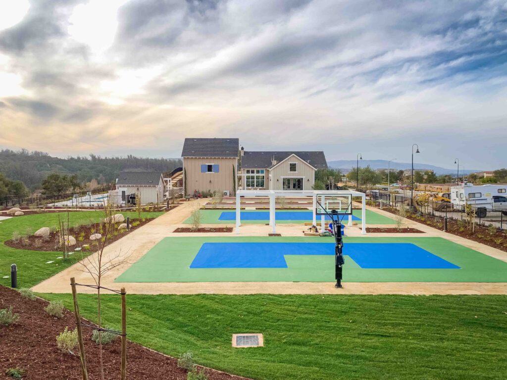 Outdoor basketball court in a community park setting.