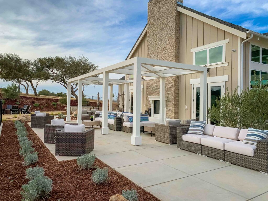 Modern backyard patio with furniture and pergola.